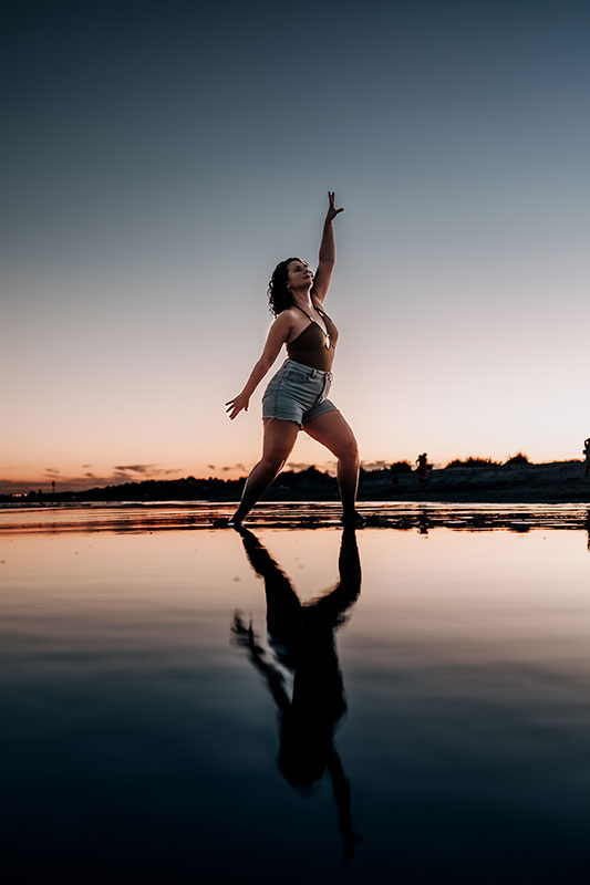 Cécile, danse-art-thérapeute, qui danse les pieds dans l'eau au soleil couchant.