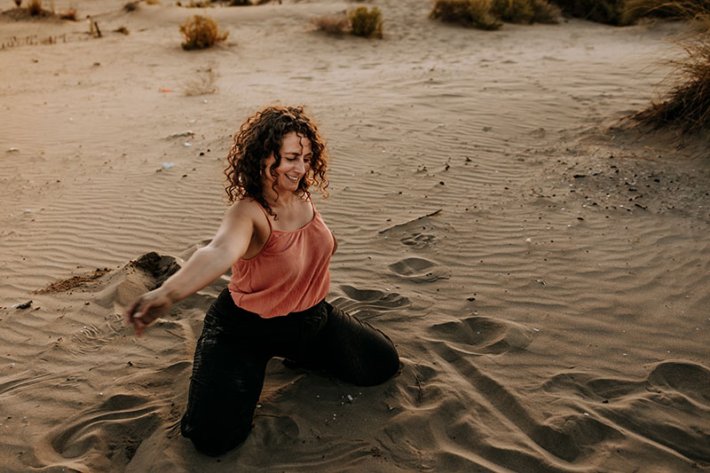 Photo de Cécile qui danse dans le sable.